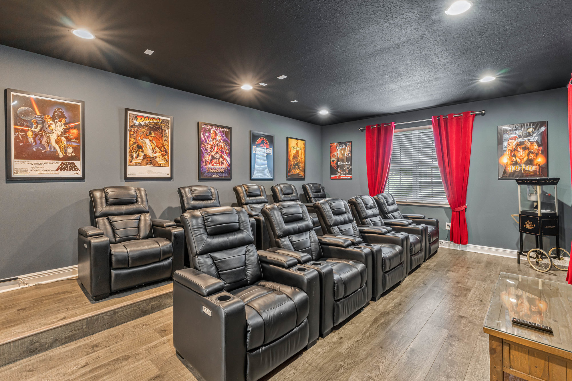 movie room with two rows of black recliners